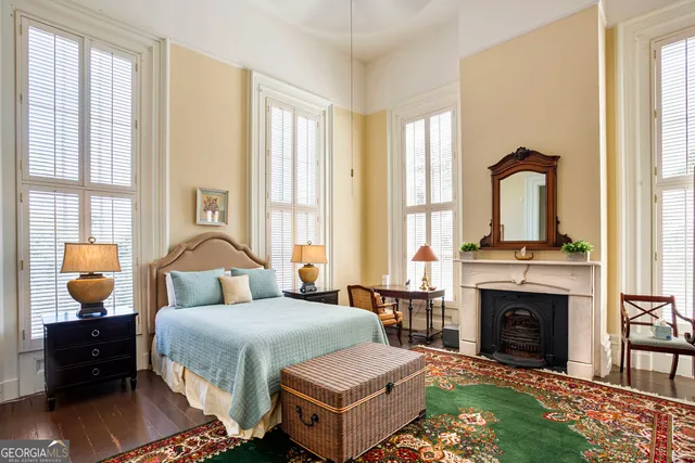 a front view of a house with a garden and trees