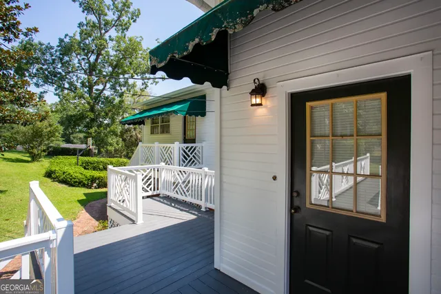 a front view of a house with a yard and trees