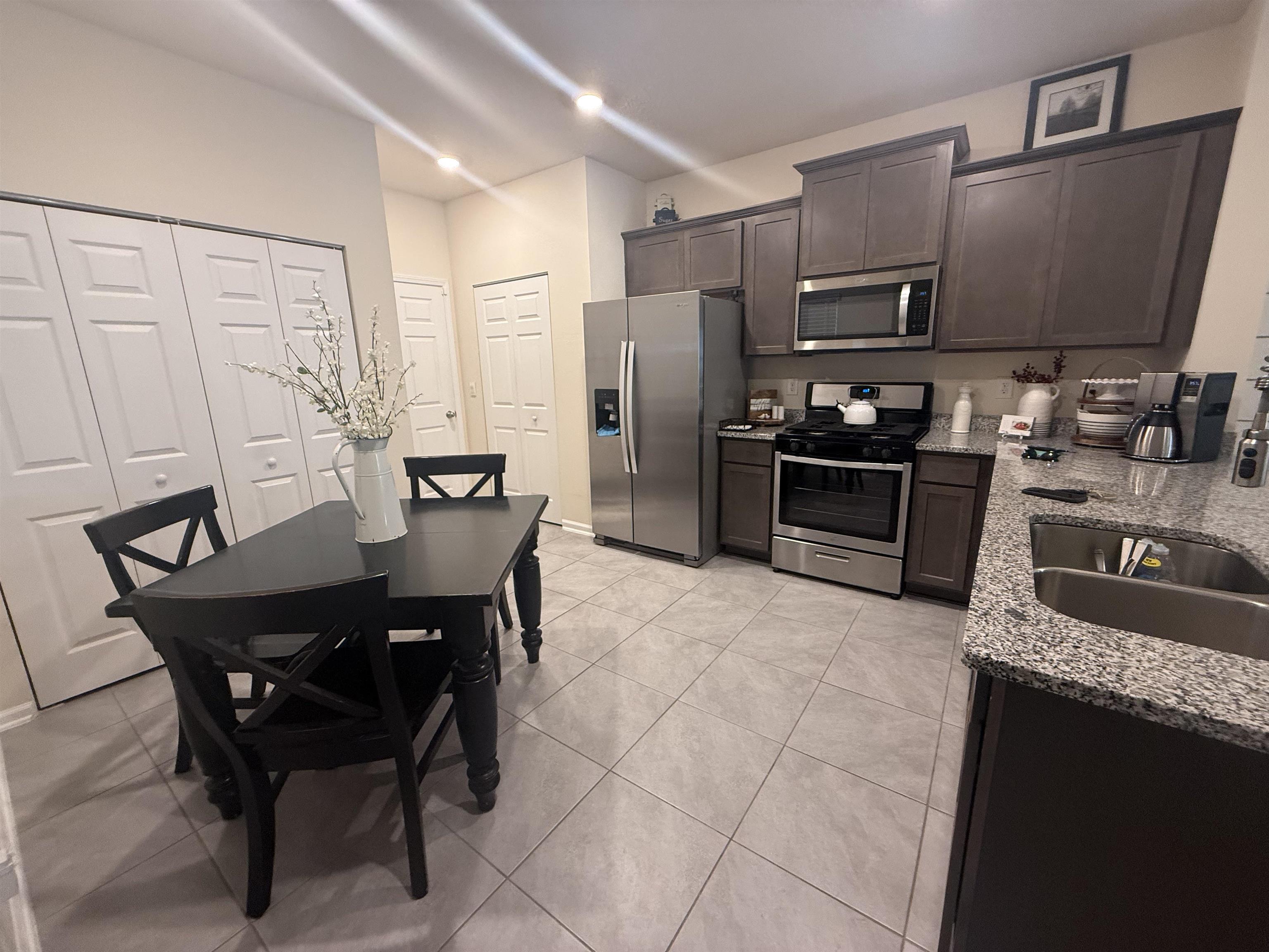 64 Coastline Way St. Augustine, FL 32092 - Photo 21 of 43 a kitchen with stainless steel appliances granite countertop a stove a refrigerator a sink a dining table and chairs