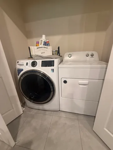 a view of a hallway with wooden floor and a bathroom