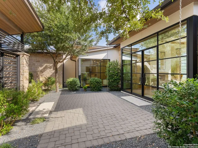 a living room with furniture large window and wooden floor