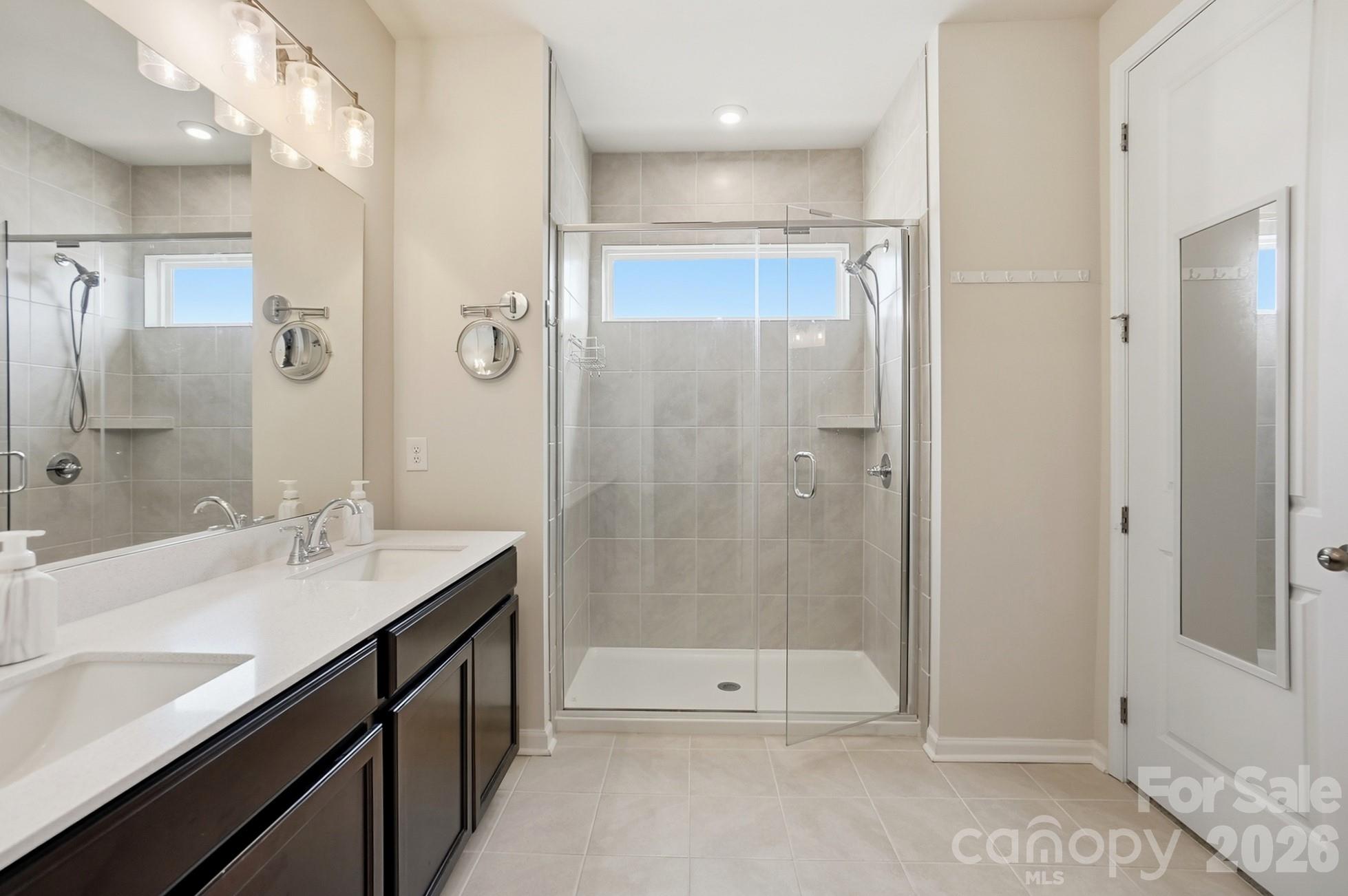 6351 Lopez Court Kannapolis, NC 28081 - Photo 27 of 48 a bathroom with a shower sink vanity and mirror