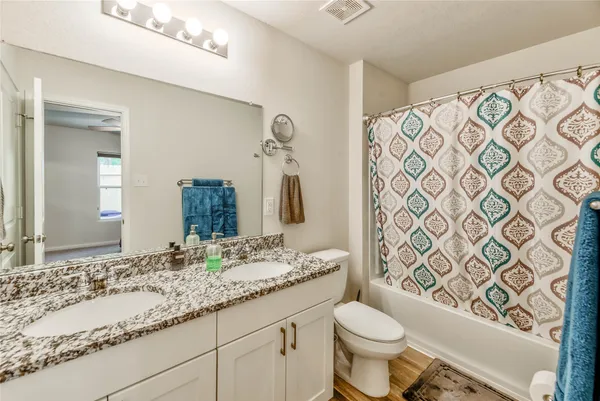 a bathroom with a granite countertop toilet sink and mirror