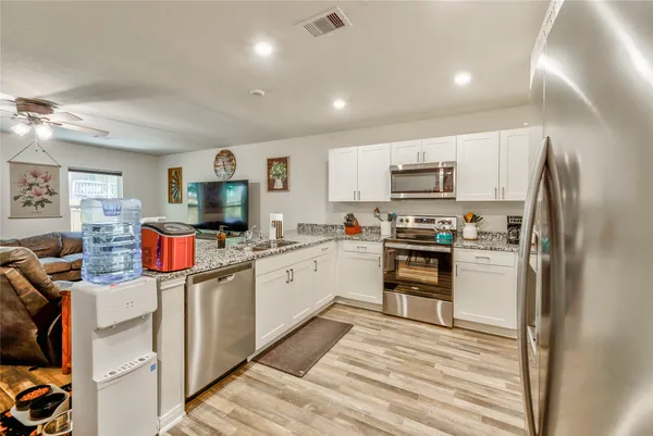 a kitchen that has a lot of cabinets and refrigerator