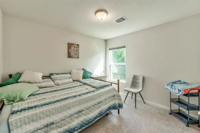 a bedroom with a bed and a chair