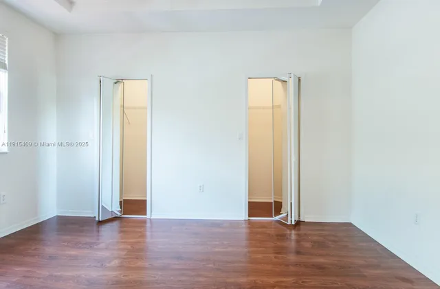 an empty room with wooden floor and closet