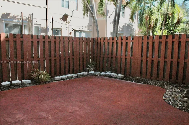 a backyard of a house with lawn chairs and wooden fence