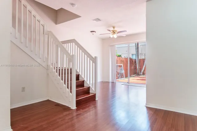 a view of a hallway with wooden floor and staircase