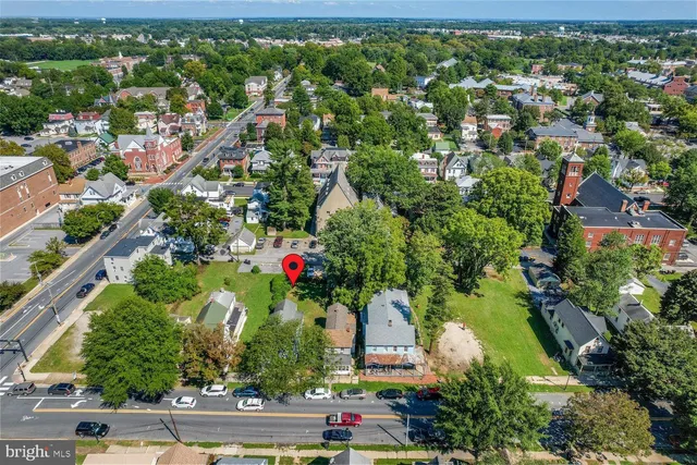 an aerial view of residential houses with outdoor space and trees