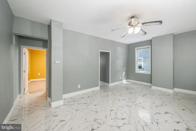 a view of an empty room with closet and a bathroom