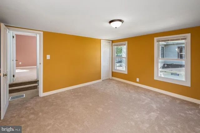 an empty room with windows and closet