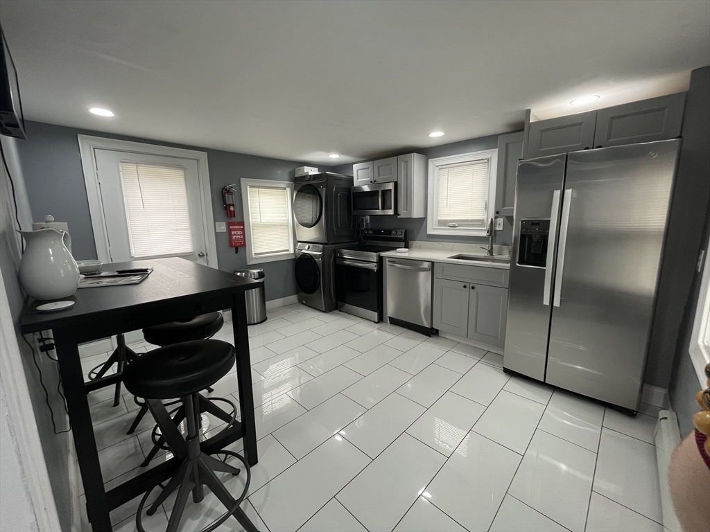 27 Overlook Road Holbrook, MA 02343 - Photo 2 of 25 a kitchen with stainless steel appliances granite countertop a refrigerator a stove a sink a dining table and chairs with wooden floor