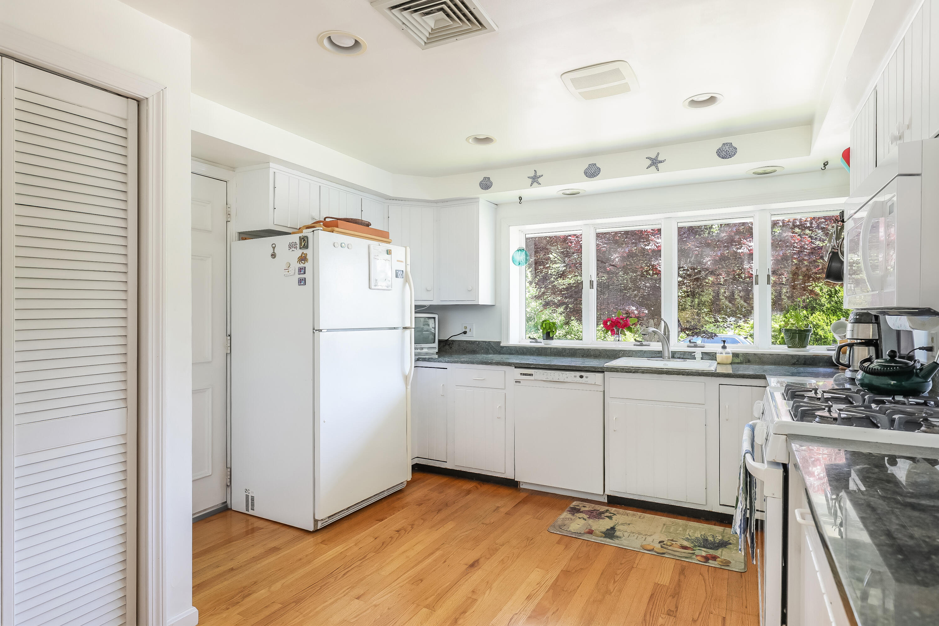 14 Captain Kidd Road East Sandwich, MA 02537 - Photo 7 of 29 a kitchen with granite countertop a refrigerator a sink and white cabinets