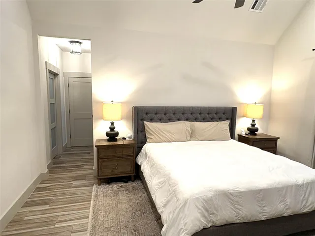 a bedroom with a bed and wooden floor