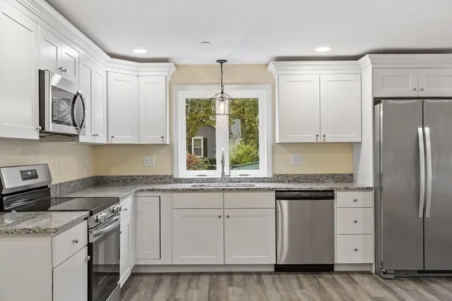a kitchen with white cabinets and white appliances