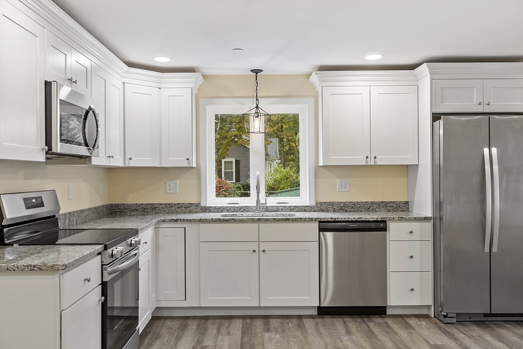 a kitchen with white cabinets and white appliances