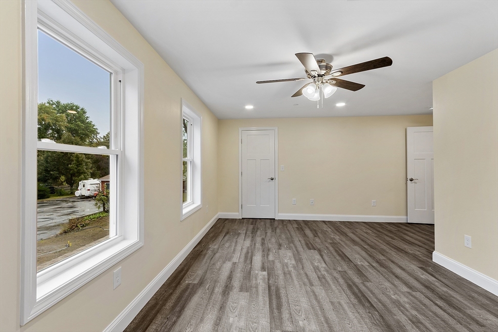 20 Townsend Street, Unit 2 Pepperell, MA 01463 - Photo 12 of 23 an empty room with wooden floor fan and windows