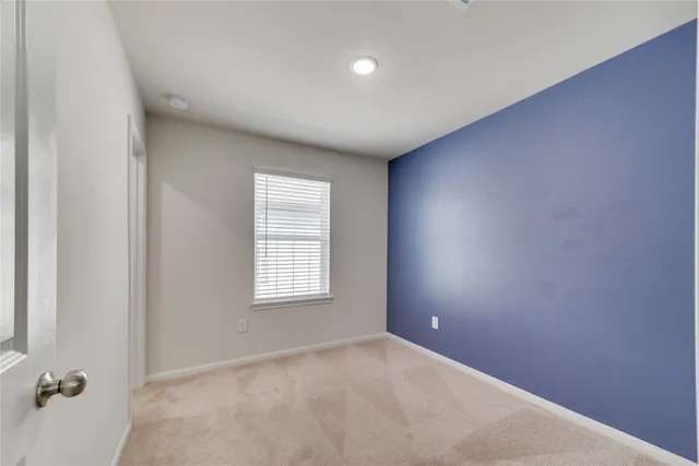 an empty room with closet and a bathroom
