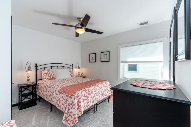 a bedroom with a bed a dresser and a window