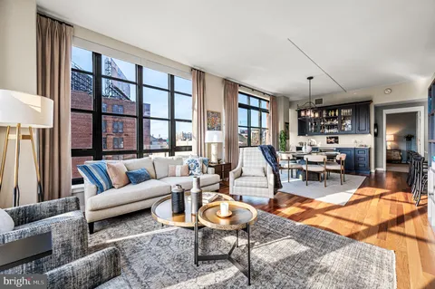 a living room with furniture a rug and a large window