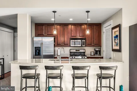a kitchen with stainless steel appliances kitchen island granite countertop a sink and cabinets