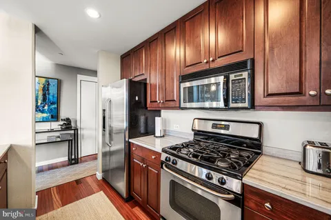 a kitchen with granite countertop wooden cabinets and stainless steel appliances