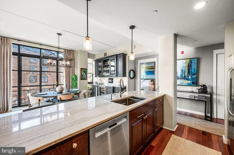 a kitchen with stainless steel appliances granite countertop a sink a counter space cabinets and furniture