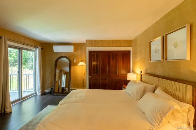 a bedroom with a large bed and wooden floor