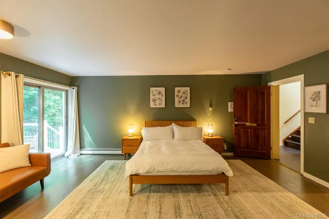 a spacious bedroom with a bed and wooden floor