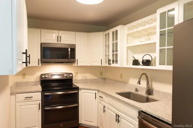 a kitchen with a sink appliances and cabinets