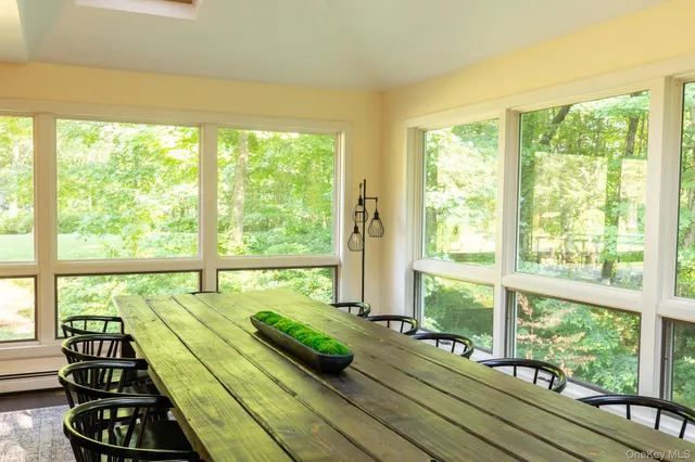 a room with pool table and windows with wooden floor