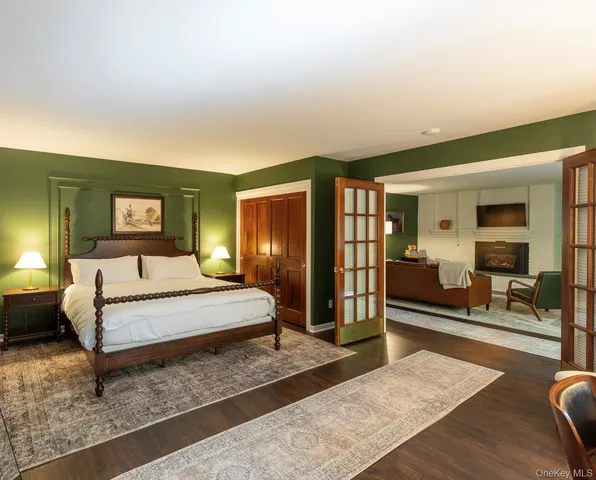 a spacious bedroom with a bed a mirror and dresser