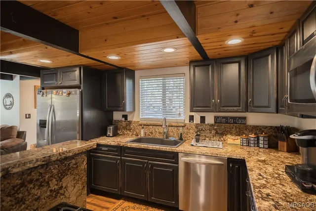 a kitchen with stainless steel appliances granite countertop a sink stove and cabinets