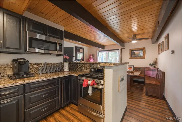 a kitchen with granite countertop lots of clutter and stainless steel appliances
