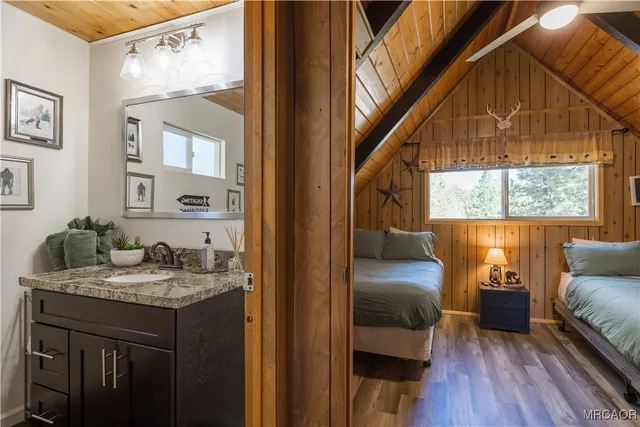 a en suite bathroom with a granite countertop tub and a wooden floor