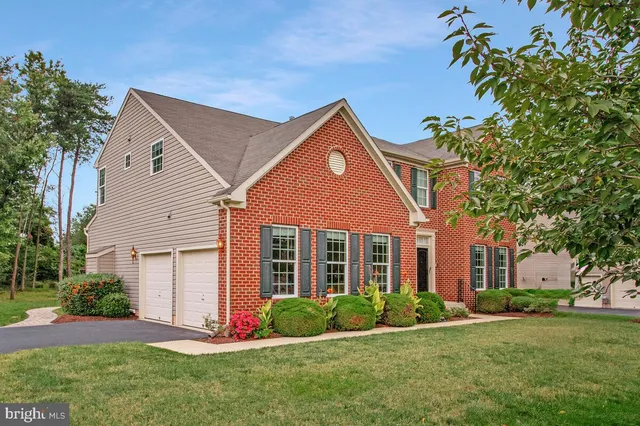 a front view of a house with a yard and trees