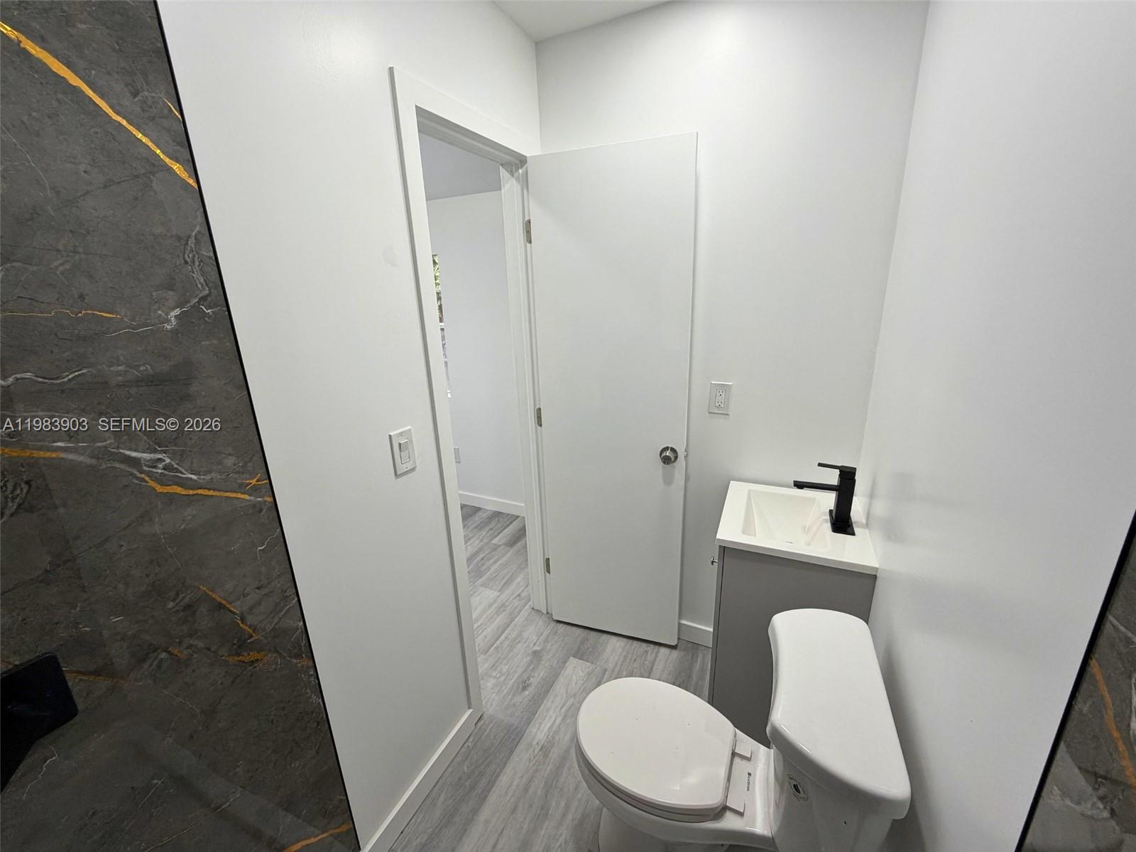 9255 Southwest 43rd Terrace Miami, FL 33165 - Photo 16 of 21 a white toilet sitting next to a sink and vanity