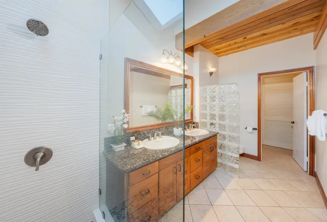 a bathroom with a granite countertop sink and a mirror