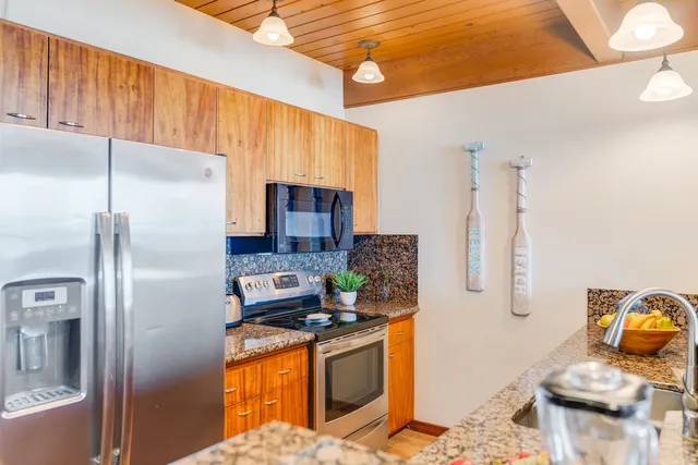 a kitchen with stainless steel appliances granite countertop a refrigerator stove and sink