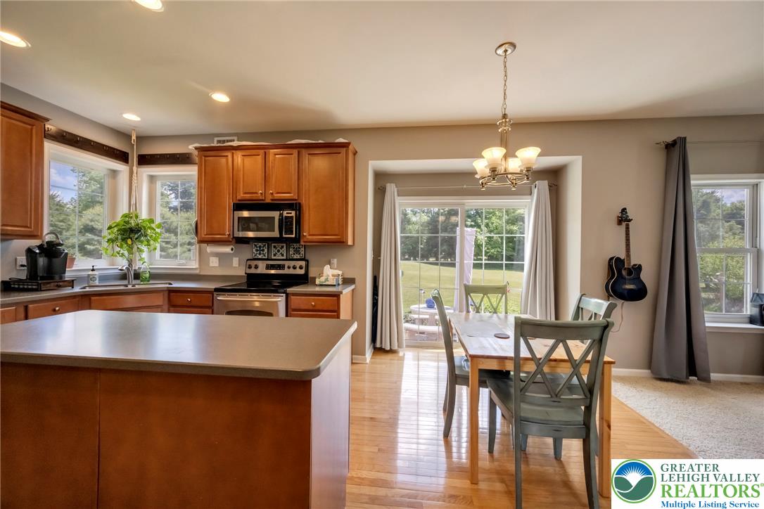 204 Bushkill Ridge Road Wind Gap, PA 18091 - Photo 11 of 48 A chef's kitchen with a large island offers a charming view of the verdant yard through sliding glass doors.