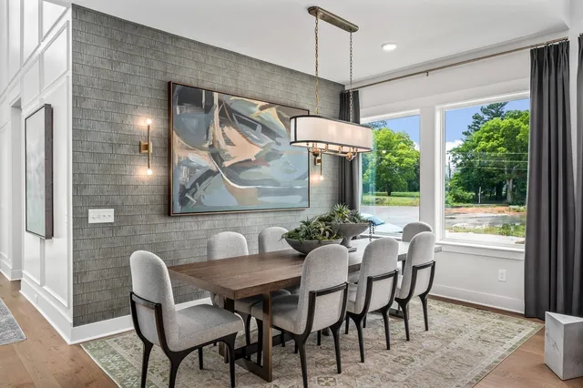 a living room with furniture a fireplace and floor to ceiling windows