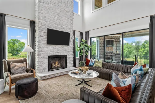 a kitchen with stainless steel appliances kitchen island granite countertop a refrigerator a sink and white cabinets