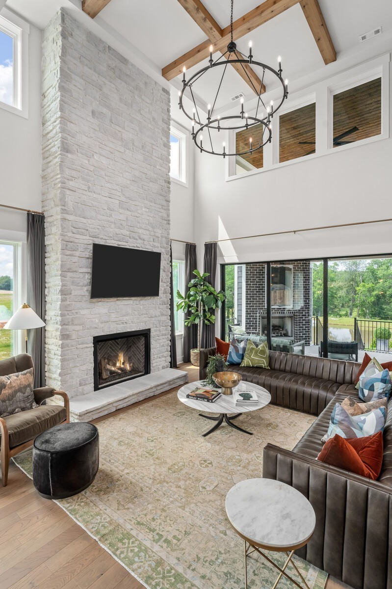 7221 Severide Street Fairview, TN 37062 - Photo 23 of 96 a living room with furniture a fireplace and floor to ceiling windows
