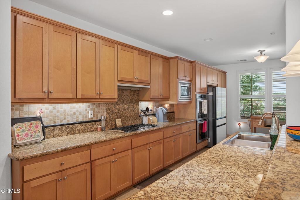1423 Windshore Way Oxnard, CA 93035 - Photo 76 of 77 a kitchen with stainless steel appliances granite countertop a refrigerator sink and cabinets