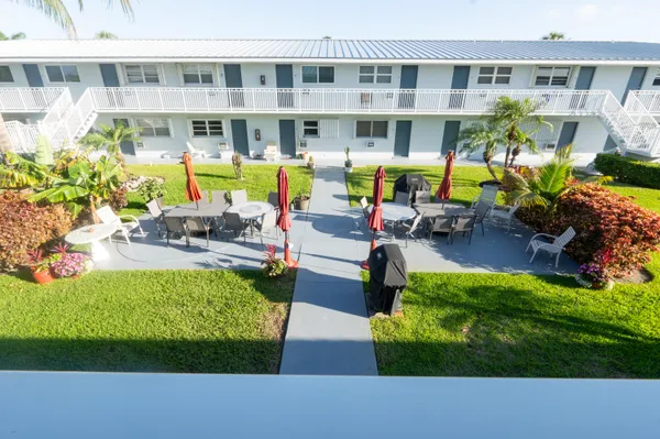 a view of a house with a big yard and potted plants