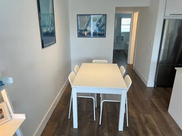 a view of a livingroom and a dining room with wooden floor