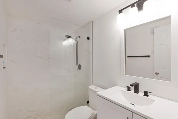 a bathroom with a sink toilet and shower