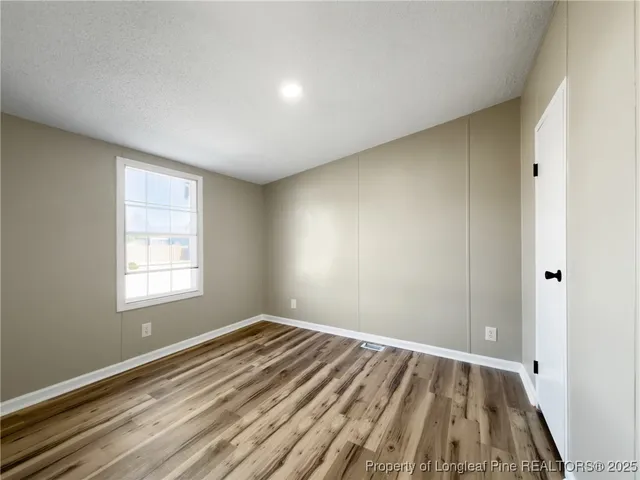 a view of a room with wooden floor and window