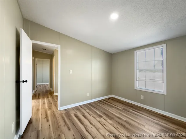 a view of a room with wooden floor and a window