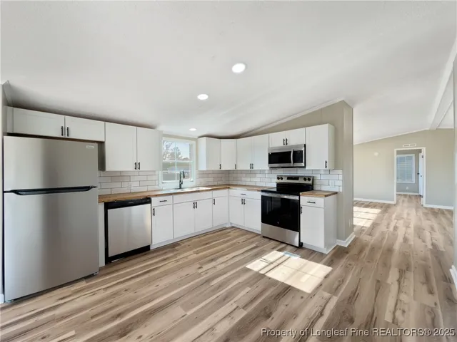 a kitchen with granite countertop a refrigerator and a stove top oven